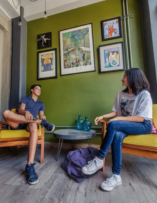 Dos personas platicando en el área de recepción del Hotel Central, decorada al estilo del mejor hotel en el Istmo de Tehuantepec.
